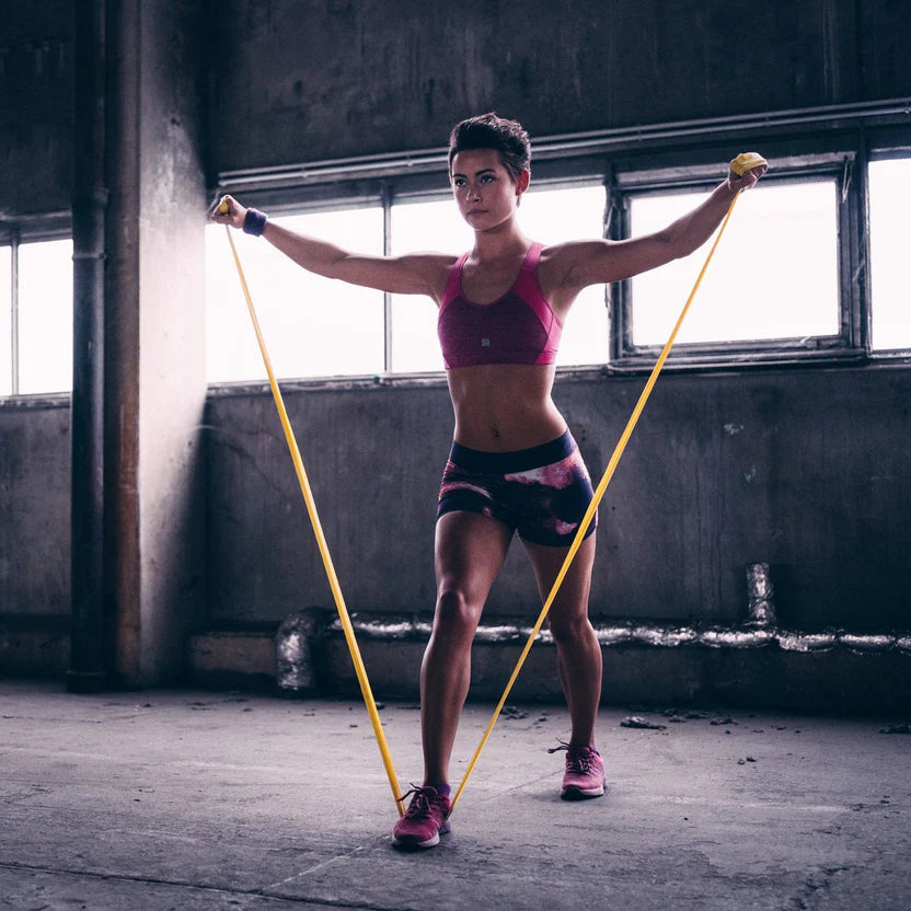 Person exercising with resistance bands in an industrial setting